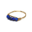 Gold ring with blue beads on a white background
